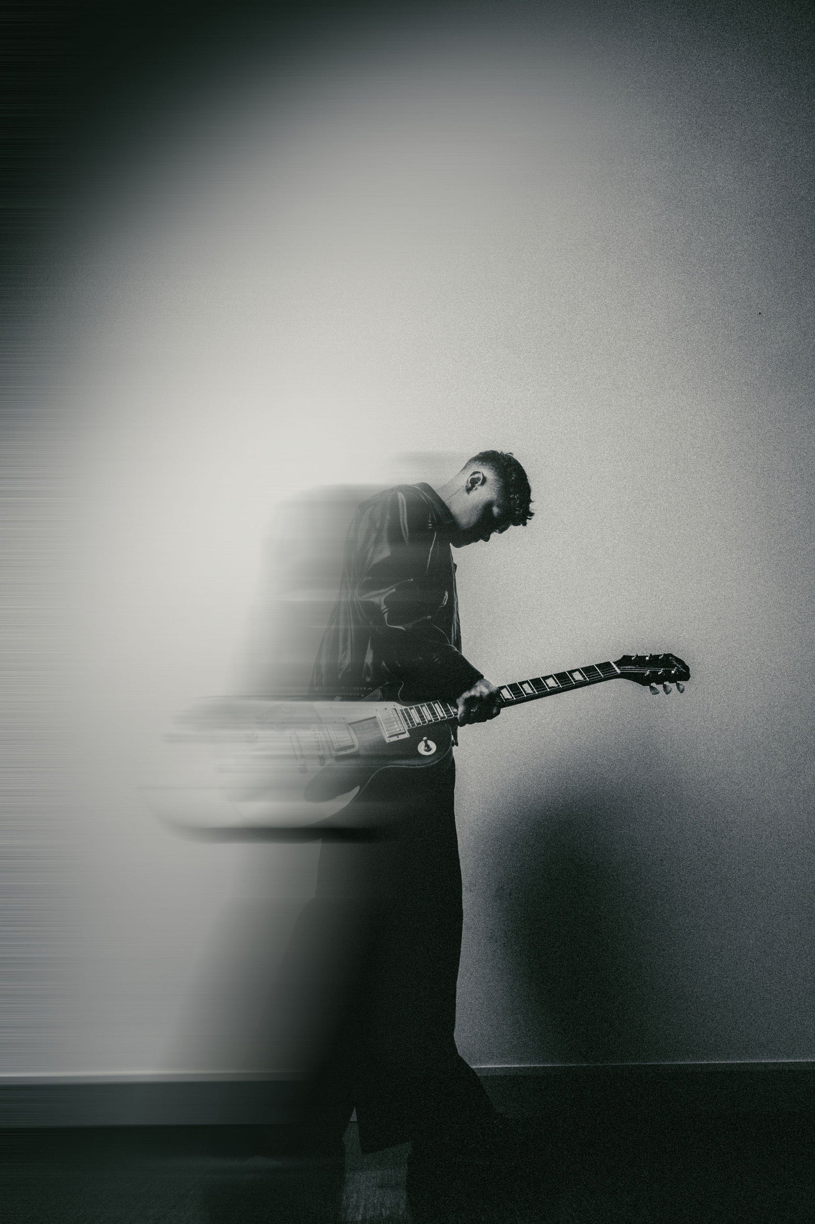 Olivier Bergeron debout avec une guitare, portrait en mouvement flou, noir et blanc